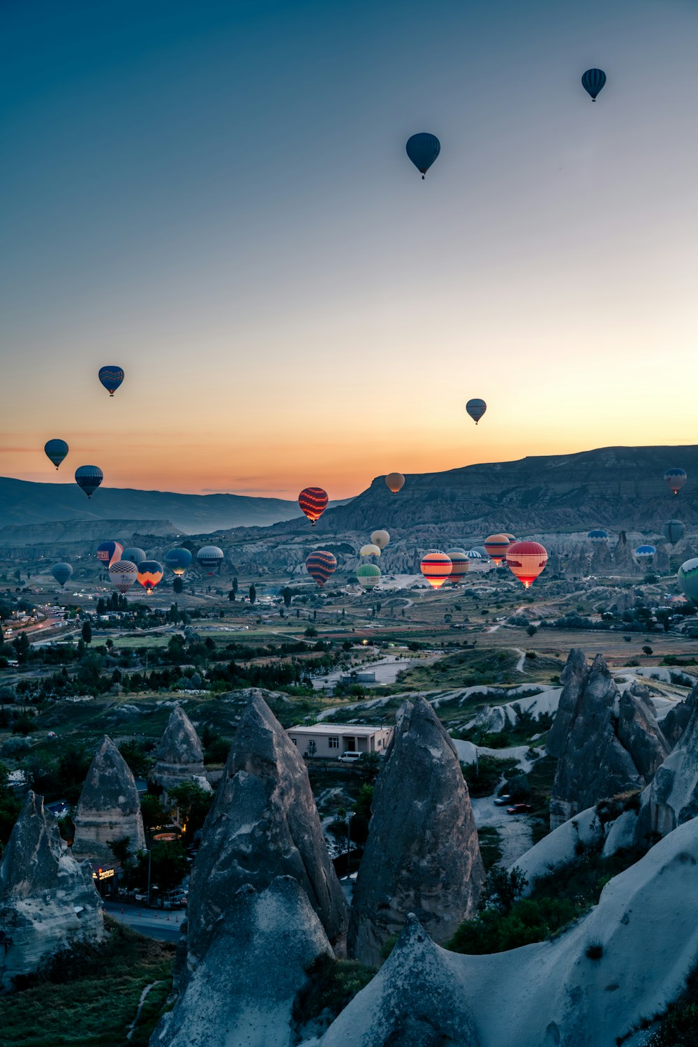 Eine Gruppe von Heißluftballons, die über ein Tal fliegen