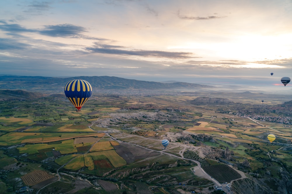 a group of hot air balloons flying over a valley