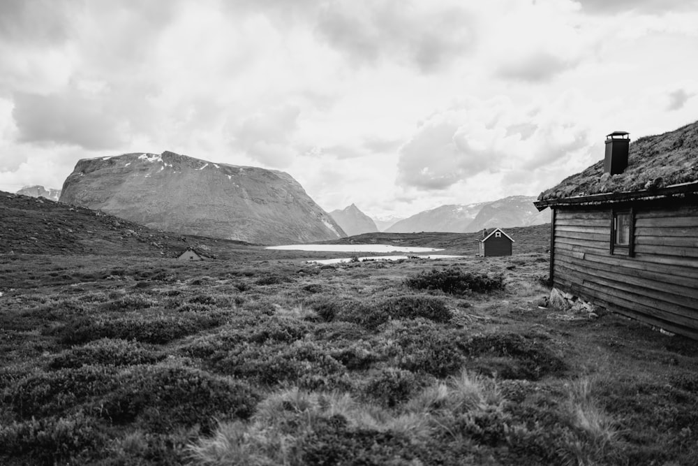 a black and white photo of a house in the mountains