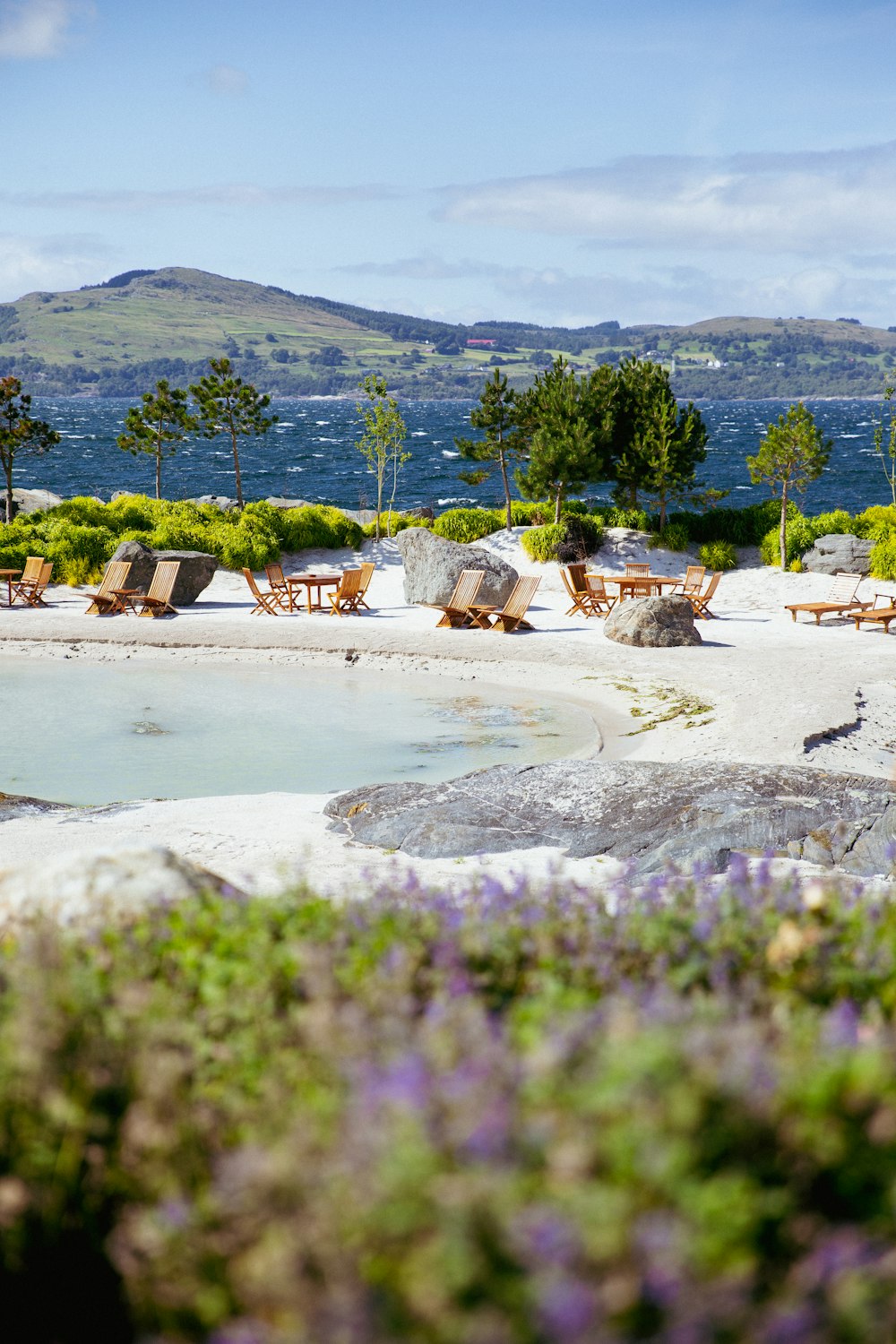 a hot spring surrounded by lounge chairs and flowers