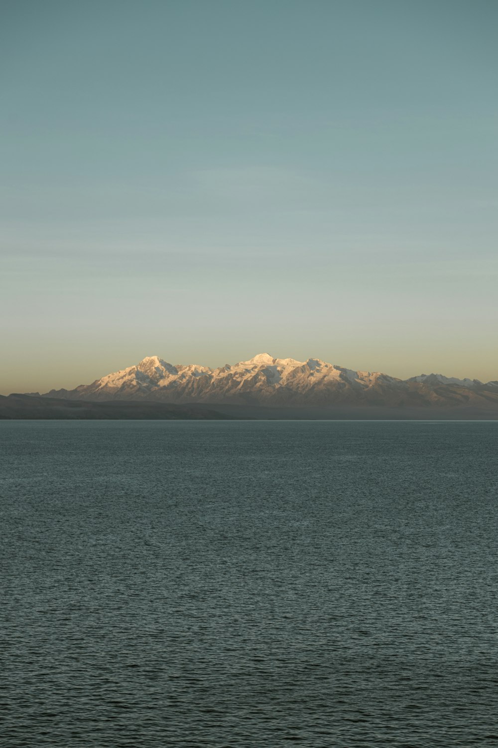 a large body of water with mountains in the background