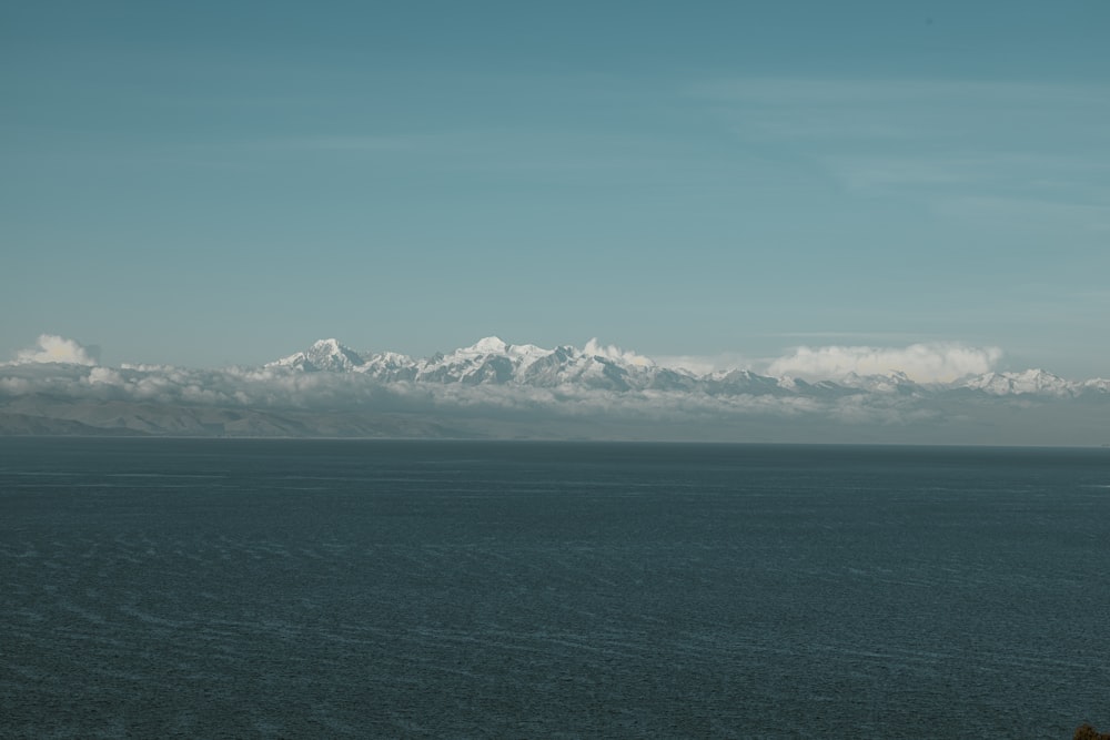 a large body of water with mountains in the background