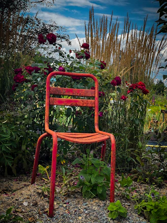 A sleek swivel patio chair positioned beside a blooming garden.