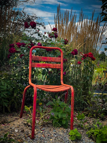 A sleek swivel patio chair positioned beside a blooming garden.
