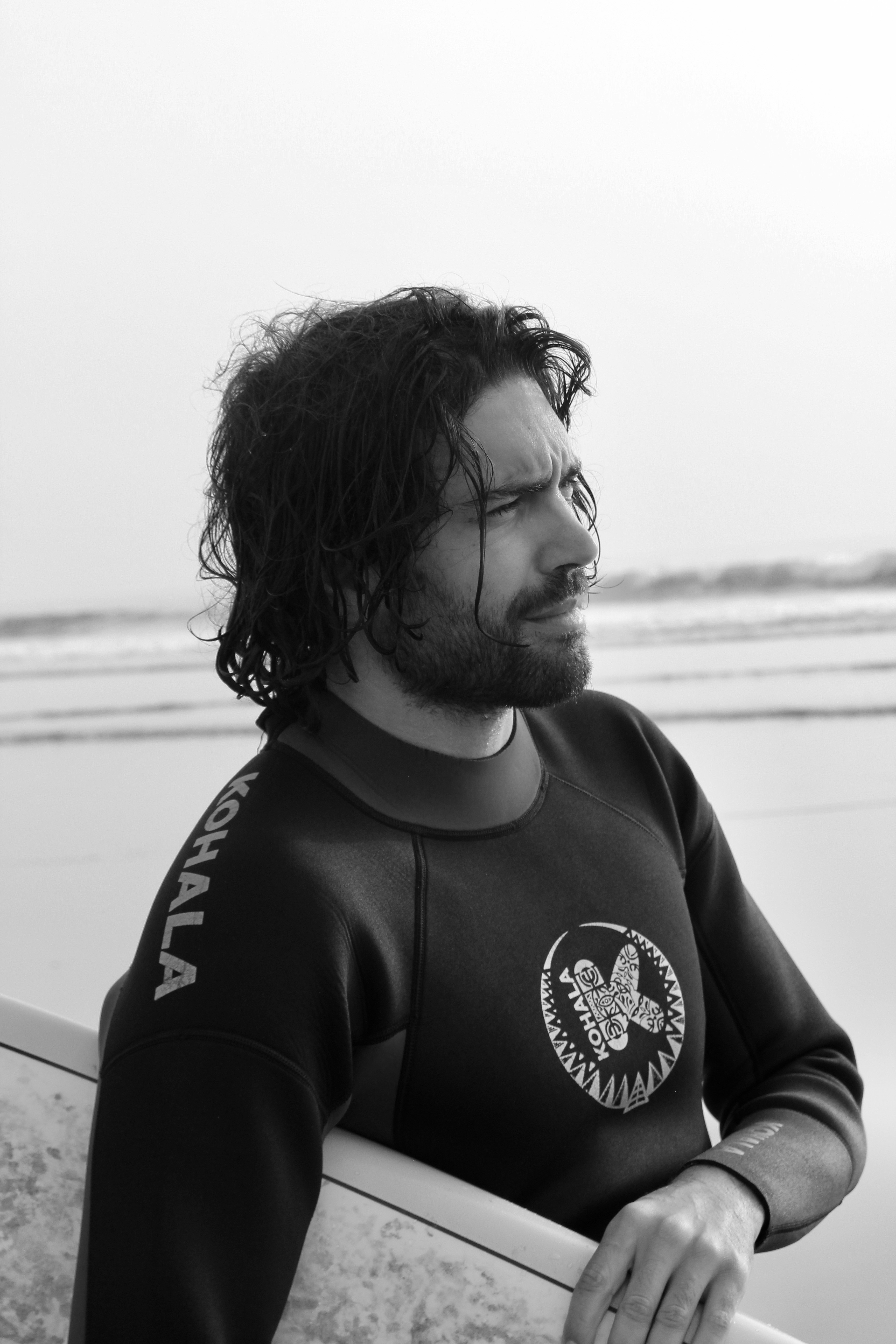 A man in a wet suit holding a surfboard photo Free Taghazout Image on