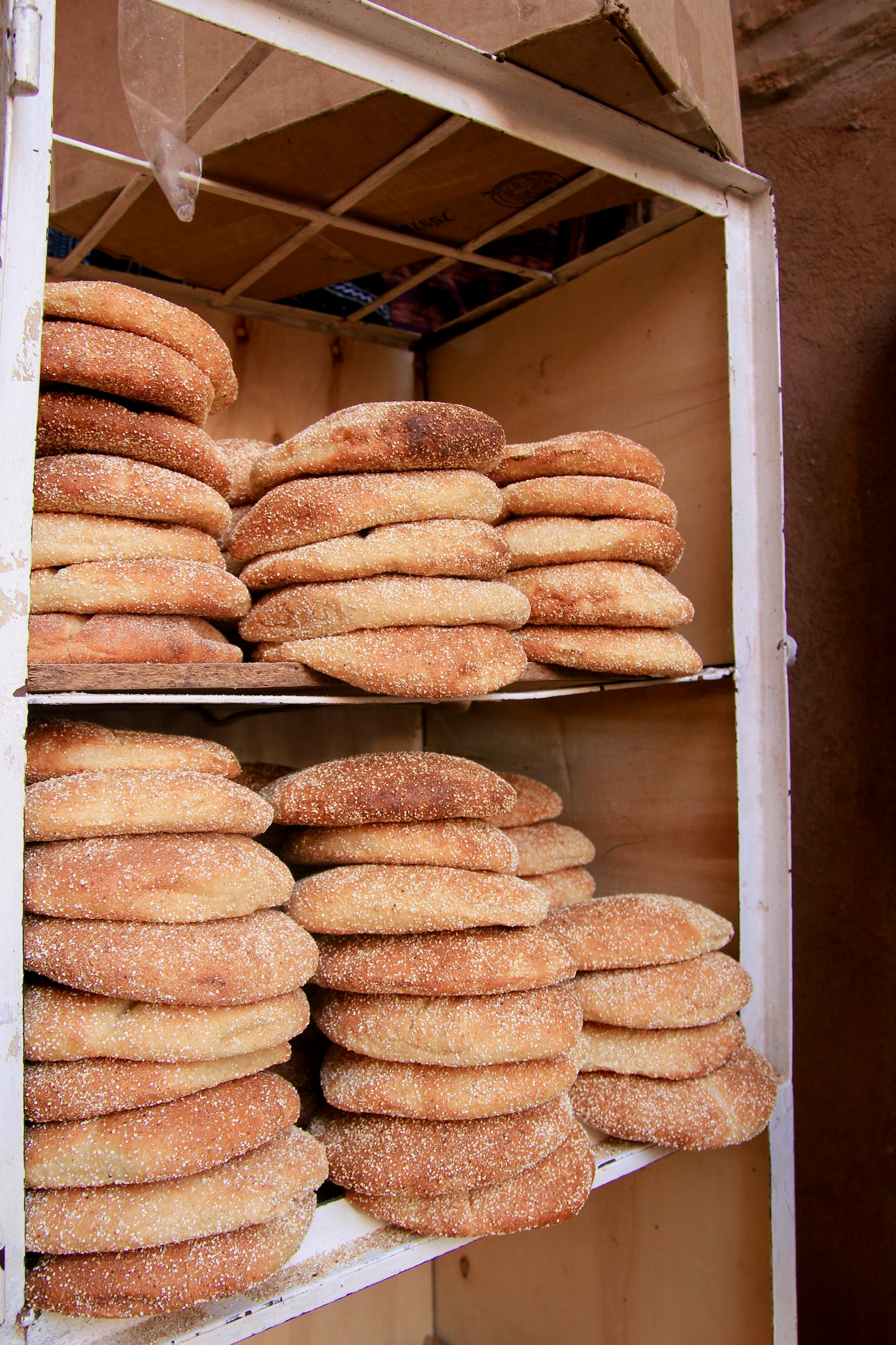 a bunch of doughnuts are stacked on a shelf