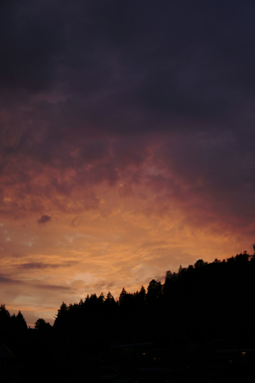 a plane flying in the sky with a sunset in the background