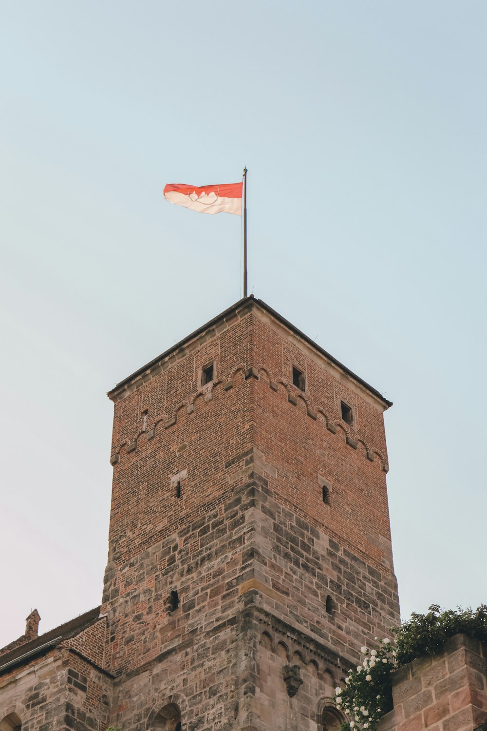 ein hohes Backsteingebäude mit einer Flagge darauf
