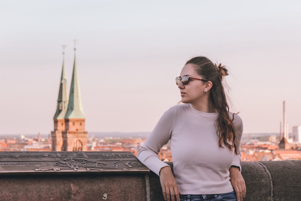 a woman standing on top of a stone wall