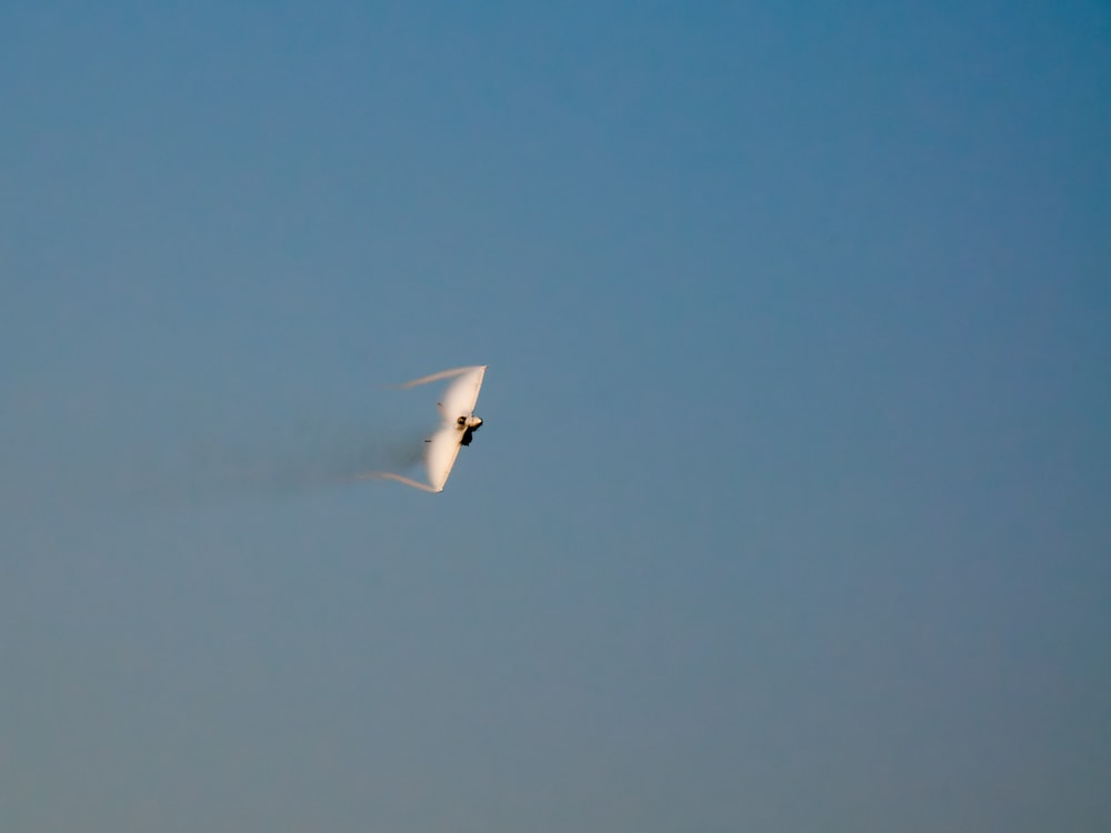 um avião branco voando através de um céu azul