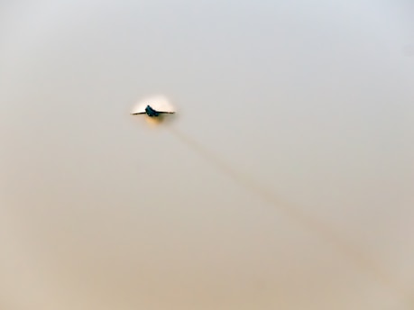Fighter jet releasing a small satellite into the sky at high speed.