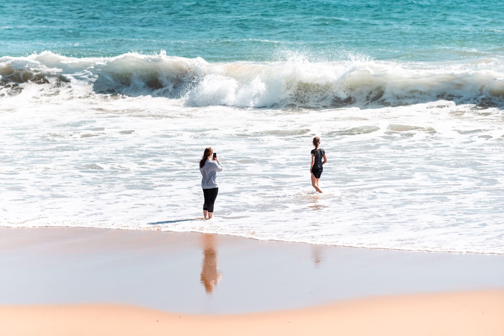 a couple of people that are standing in the water