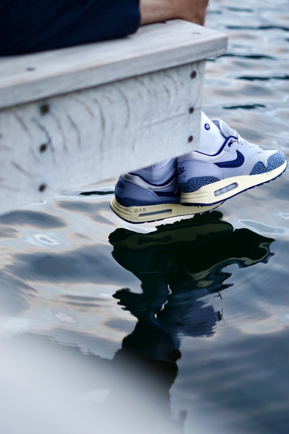 a pair of shoes sitting on top of a body of water