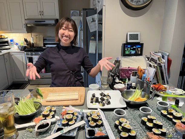 A warm kitchen scene with the Japanese chef preparing colorful sushi rolls.
