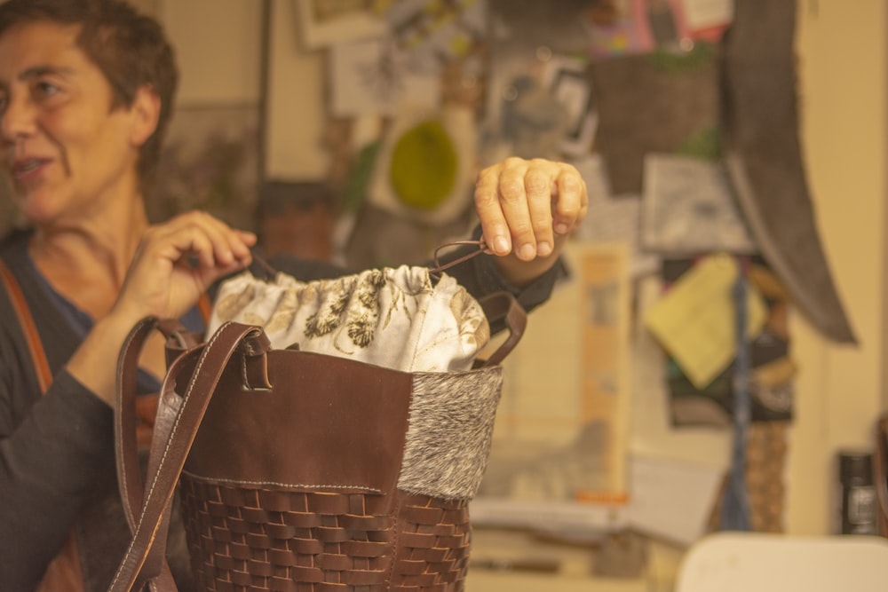 a woman holding a brown and white basket