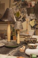a table topped with a bowl and two lamps