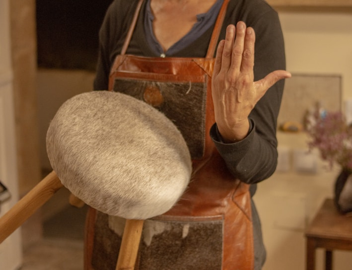 a woman in a brown apron holding a wooden spatula