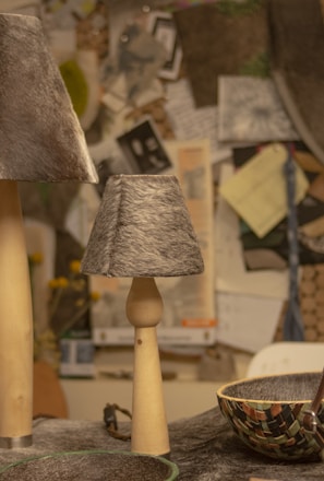 a table topped with a bowl and two lamps