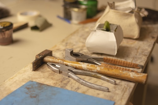 Construction tools and materials arranged on a wooden workbench.