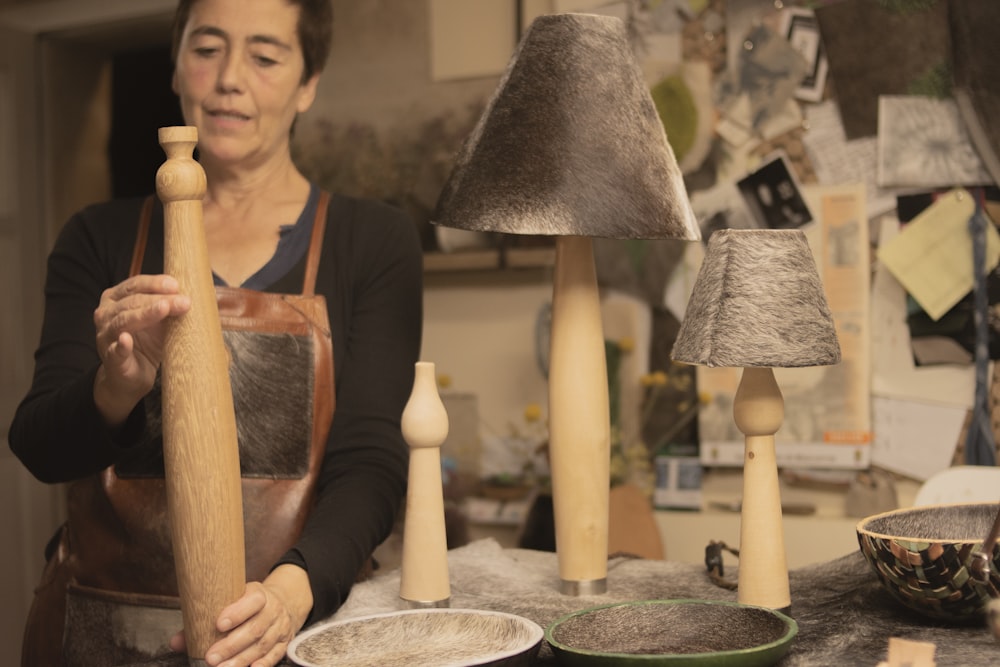 a woman in an apron holding a wooden stick