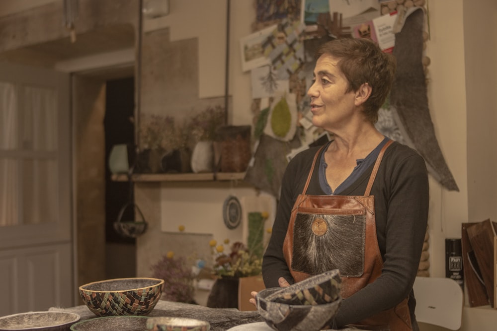 a woman standing in a kitchen preparing food