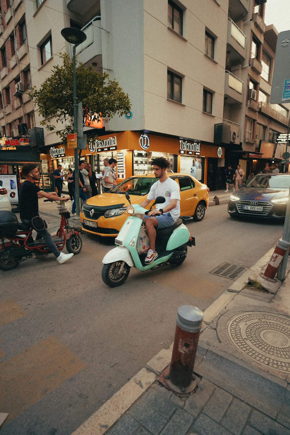 a man riding a scooter down a city street