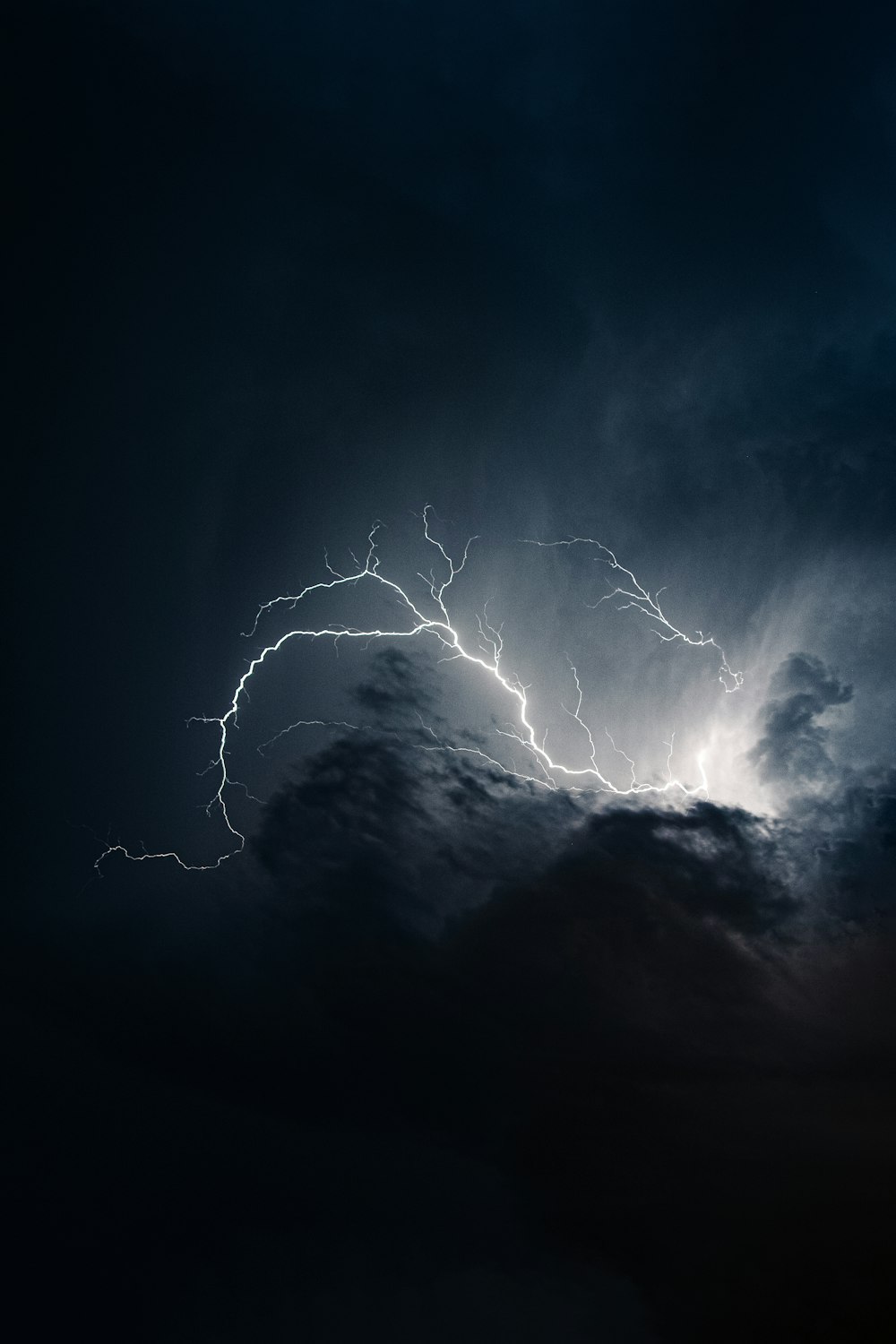 a lightning bolt hitting through a dark cloudy sky