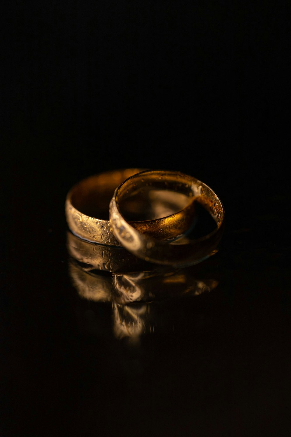 two wedding rings sitting on top of a table
