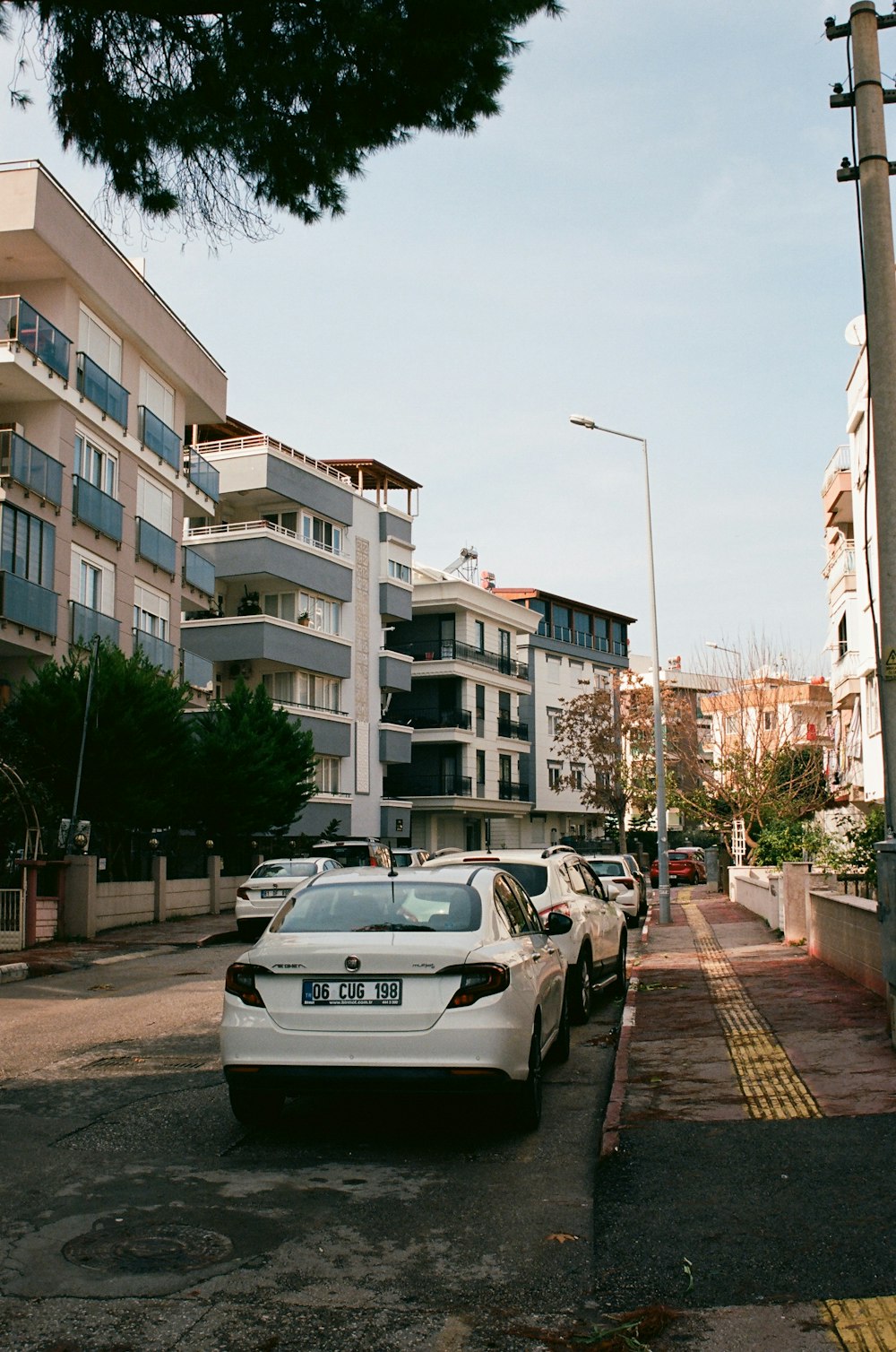 cars parked in a parking lot in front of apartment buildings