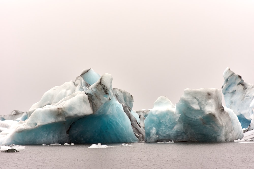 a group of icebergs floating on top of a body of water