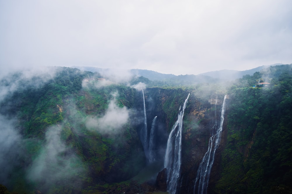 a large waterfall surrounded by lush green trees