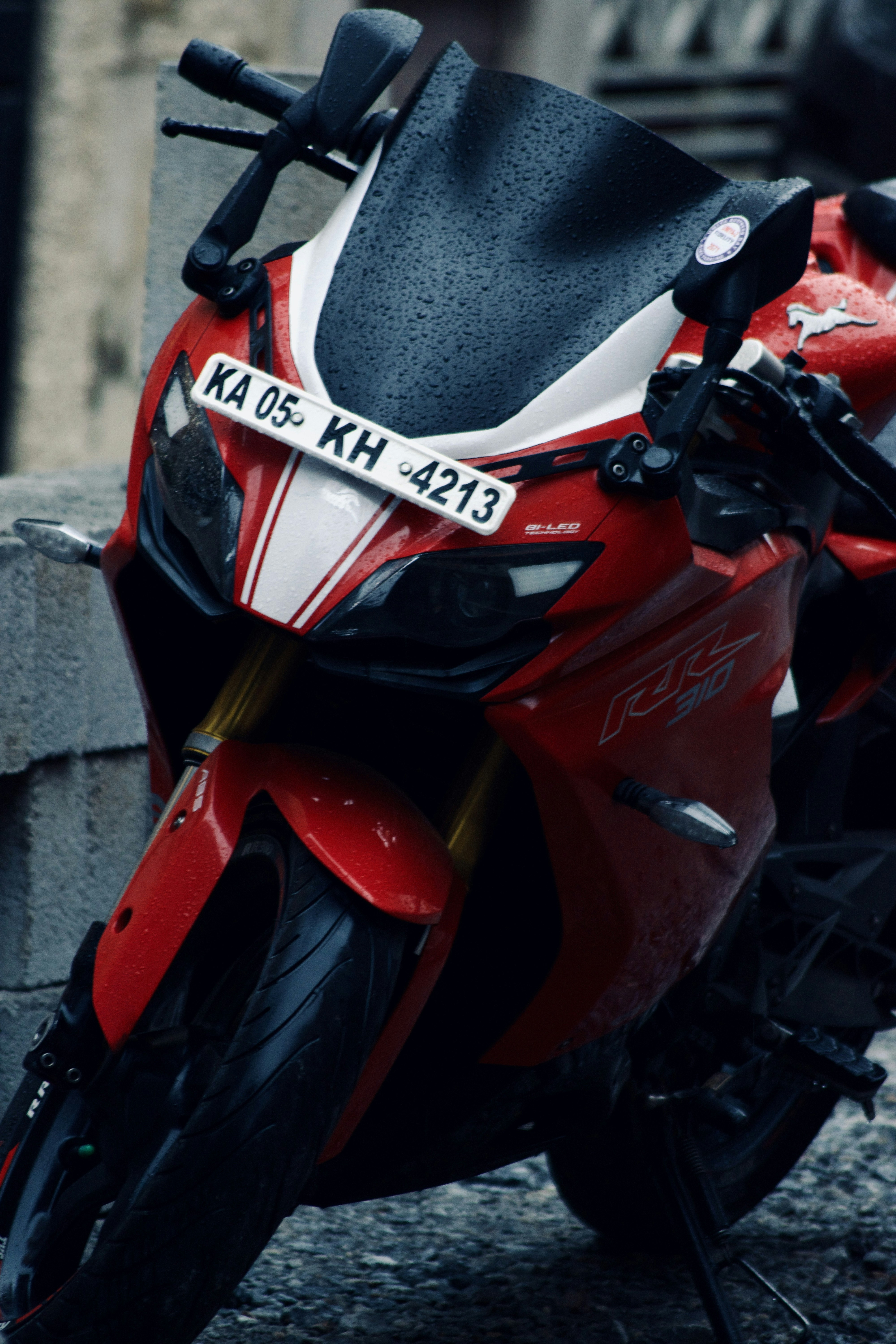 a red and white motorcycle parked next to a building