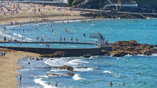 A lively beach scene with turquoise waves and sunbathers enjoying the warmth.