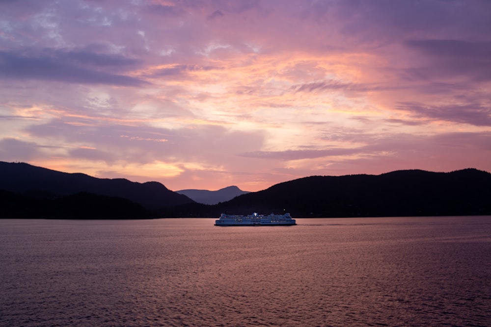 a cruise ship in the water at sunset