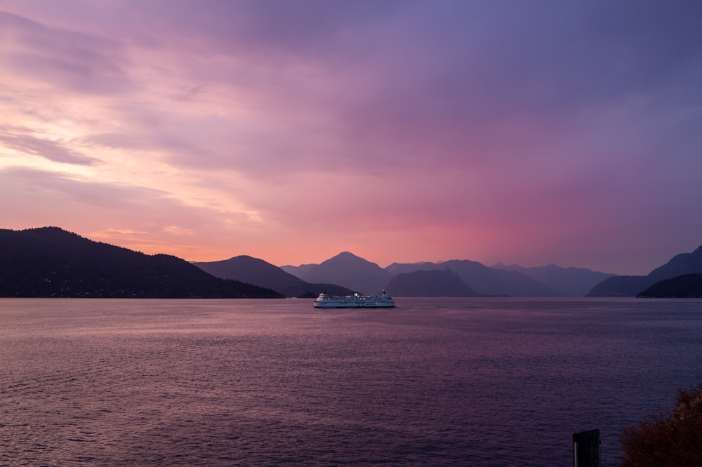 a cruise ship in the water with mountains in the background