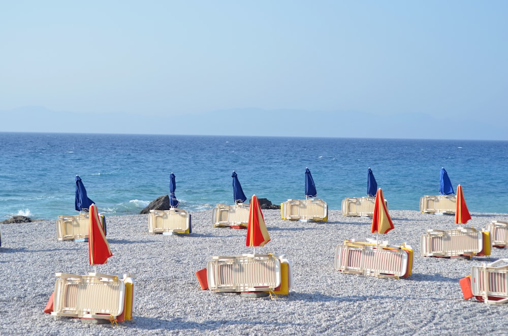 a bunch of chairs and umbrellas on a beach