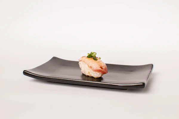 Maki roll dengan saus spesial di piring hitam