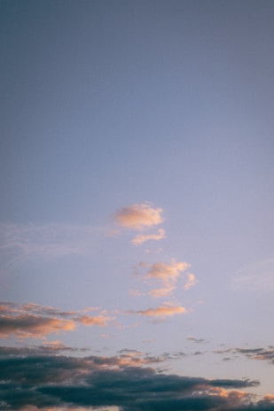 A serene anime-inspired scene showing a glowing sky with gentle gradients and floating cloud elements.