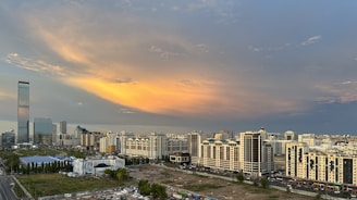 A vibrant cityscape at sunset showcasing modern residential and commercial buildings developed by Seed and Sow Development.