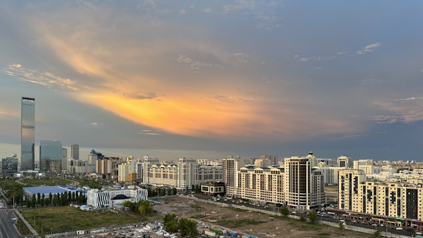 A vibrant cityscape at sunset showcasing modern residential and commercial buildings developed by Seed and Sow Development.