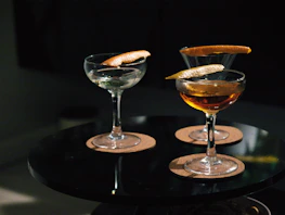 Guests enjoying cocktails on a cozy terrace with black background ambiance.