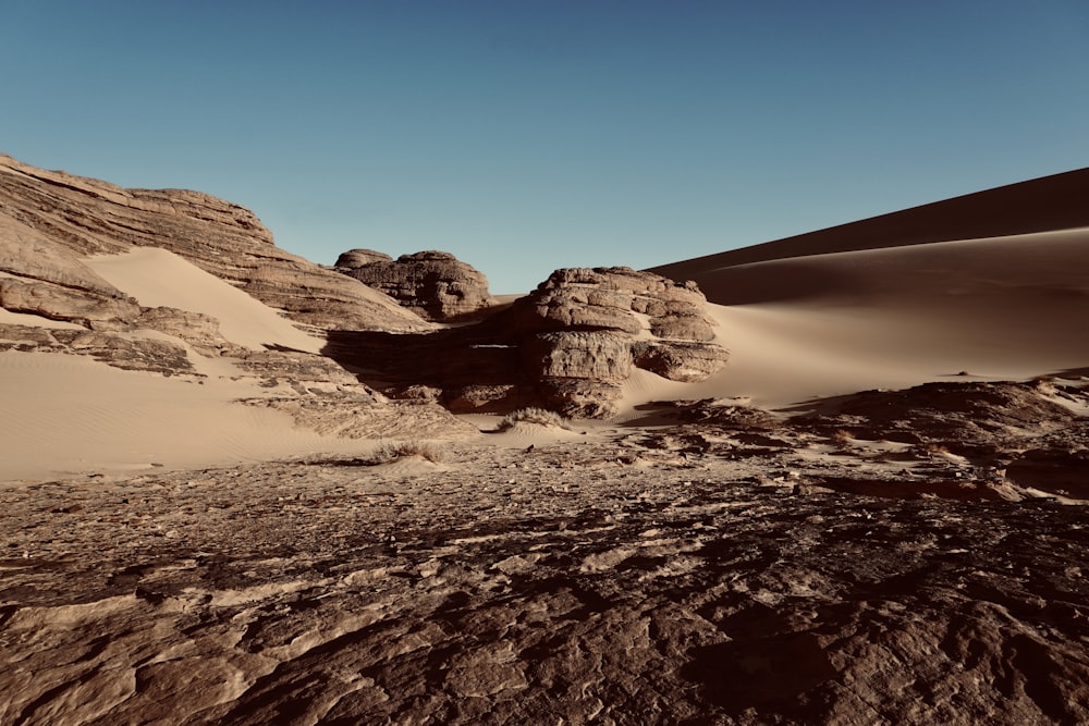 a desert landscape with rocks and sand dunes