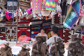 Close-up of smiling locals sharing traditional crafts in a bustling market.