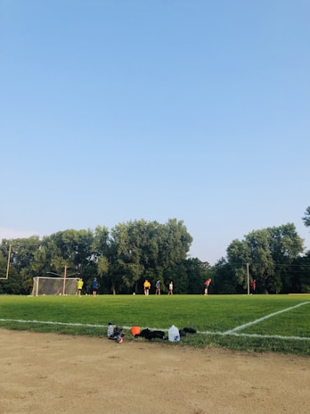 A group of middle school students playing soccer on the well-maintained school sports field.