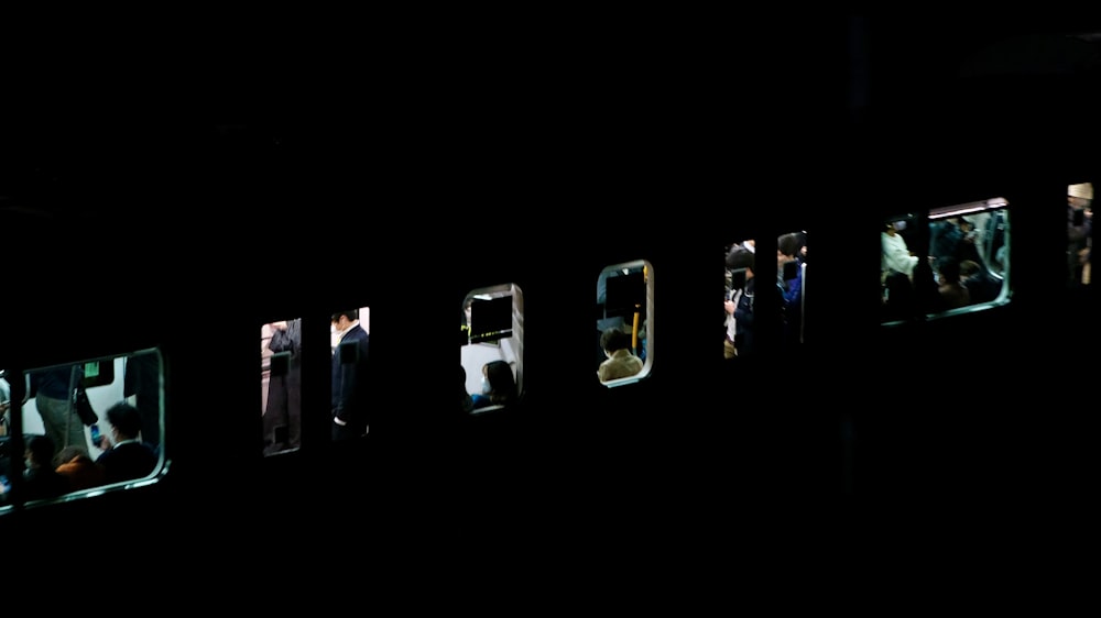 un groupe de personnes debout dans une fenêtre la nuit