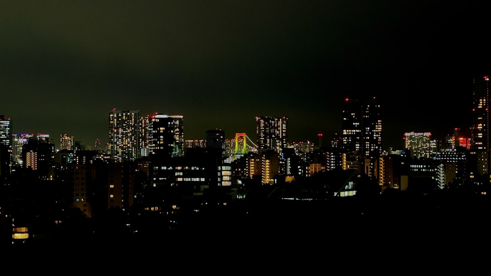 Una vista de una ciudad por la noche desde la cima de una colina