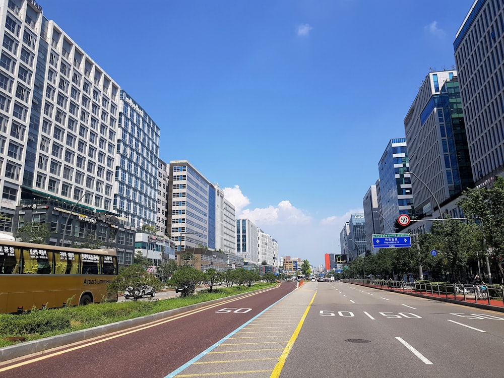 a city street lined with tall buildings and a yellow bus