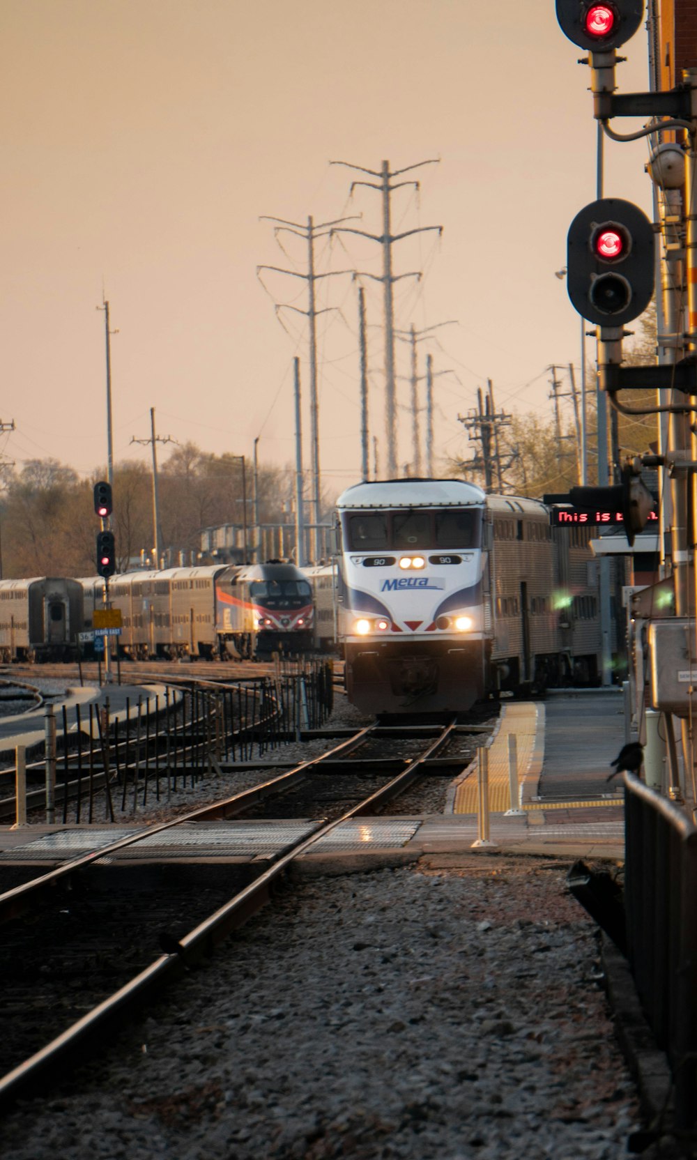 a train traveling down train tracks next to a traffic light