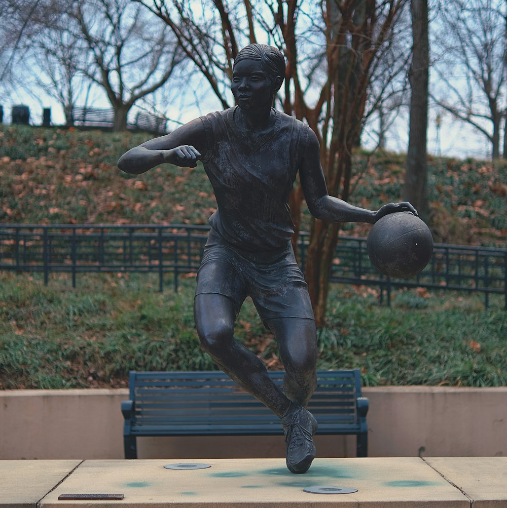 uma estátua de um homem segurando um basquete