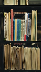 a bookshelf filled with lots of books and papers